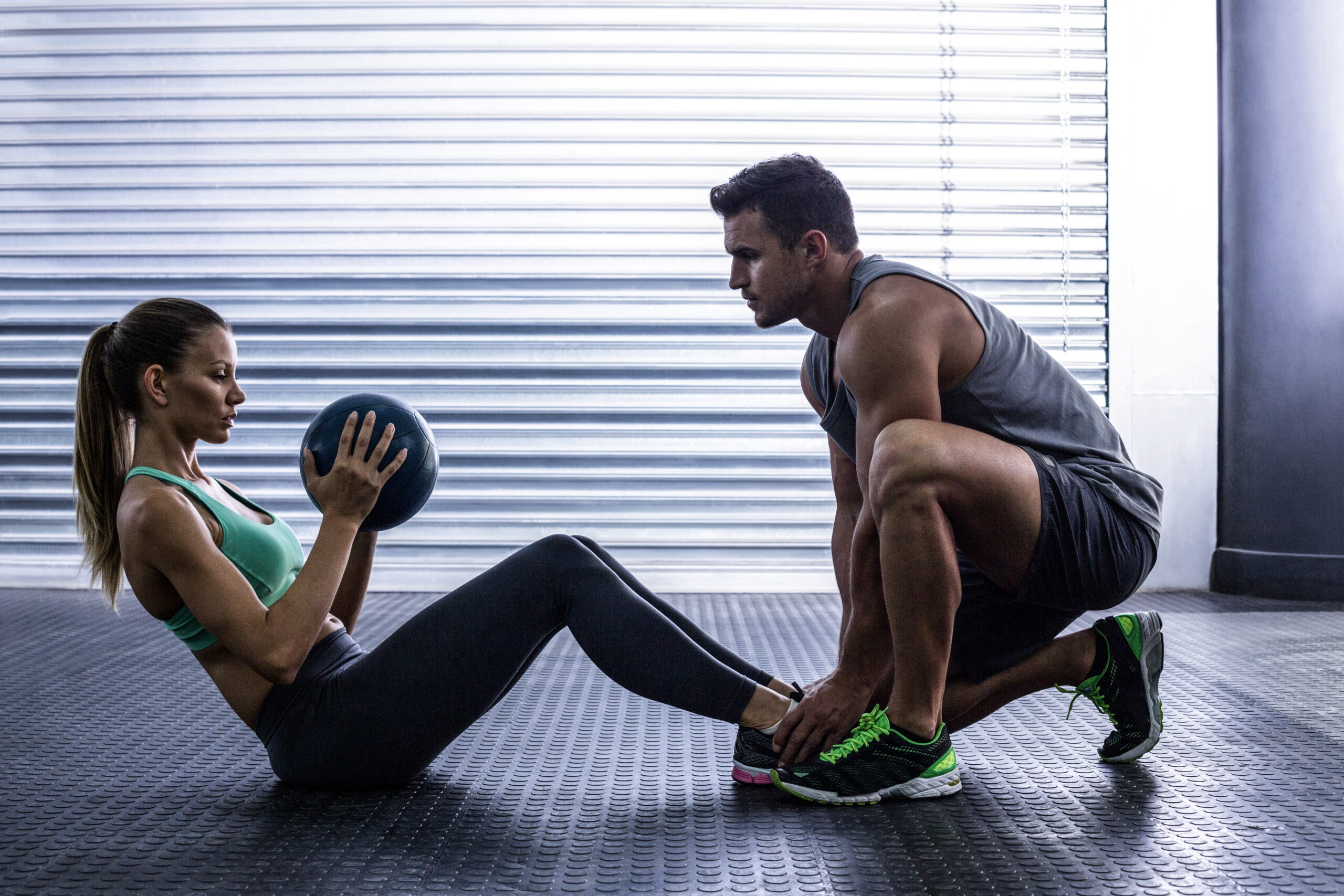 Side View Of A Muscular Couple Doing Abdominal Ball Exercise